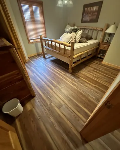 Rustic wood-look plank floor in a log-style bedroom